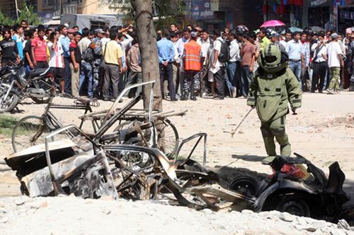 A member of the bomb-defusing squad inspects the car destroyed when a socket bomb went off in Basundhara, Kathmandu, Tuesday morning. Four people were injured in the blast, and windows of the Ishan Bal Nursing Home were shattered.