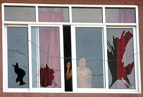 SHELL SHOCK: A girl looks out after a socket bomb destroyed a car in Basundhara, Kathmandu, on Tuesday. Four people were injured and windows of neighbouring buildings, including Ishan Bal Nursing Home, were shattered.