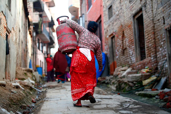 A woman carries an empty cooking gas cylinder to a gas depot in Khokana on Wednesday. The ongoing blockade has caused severe fuel shortage in the country.