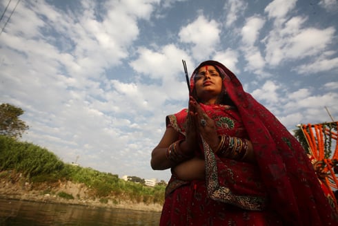 LIFE GIVER: A woman offers her prayers to the setting sun during Chhat festival on the banks of the Bagmati in Thapathali on Friday.