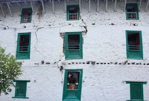 An old woman inspects her house in Dolakha on Sunday, fifteen days after the earthquake.