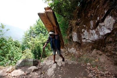 DAILY TREKKING: A porter carries pieces of wood on the way to Monjo, a small village in the Khumbu region, on Sunday.