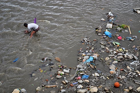 NO LUCK : A man looking through the pile of waste swept by Bishnumati river near Tahachal on Monday.