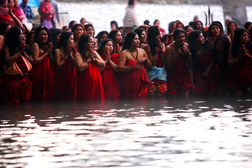 Women take a dip in the Salinadi River on the first day of Swasthani Bratakatha festival at Sankhu on Monday.
