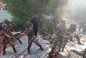 UNDER CONTROL: Soldiers recover books from the shop in Thamel that caught fire on Thursday night.