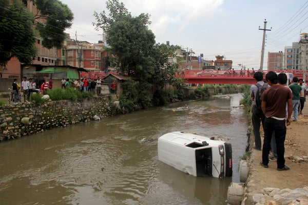 Bystanders looking at a car that fell into Dhobi Khola at Anamnagar on Tuesday.
