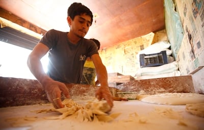 SNACK TIME: A worker prepares dough for salty crackers at a tea stall in Pulchok on Thursday.