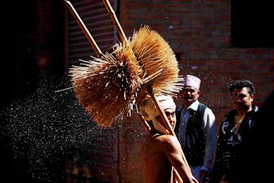 SPARKLING WATER: A Hindu devotee sprinkles holy water during Madhav Narayan Festival in Thecho village on Friday.