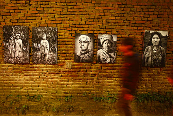 A passerby walks by portraits on display at Twaliko Tol in Patan on Tuesday. The portraits are part of photographer Kishor K Sharma's exhibition 'Living in the mist- The Last Nomads of Nepal' during Photo Kathmandu.