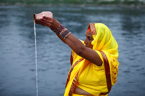 A devotee offers prayers to the setting sun during the Chhat festival at Bagmati River in Kupondole on Tuesday. Chhat is a four-day long festival that honours the sun god by praying at sunrise and sunset, and seeking blessings by giving offerings.