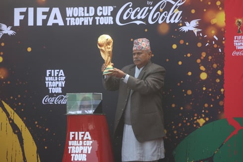 HEAVY STUFF: President Ram Baran Yadav lifts the FIFA World Cup trophy at Dasrath Stadium on Saturday.The trophy will be taken to 89 countries during this year's FIFA World Cup Trophy tour.