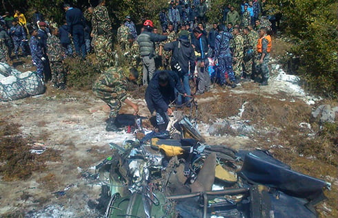TRAGEDY: Nepal Army and Nepal Police rescuers at the Nepal Airlines plane crash at Masine lekh in Argakhachi on Monday morning. All 18 passengers on board were killed in the crash.
