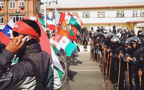 Opposition protesters from the 31 party alliance stick their party flags onto the barbed wire fence set up by the Nepal Police and Armed Police Force in Baneshwor on Thursday.