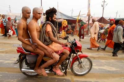 IN A HURRY: Hindu holy men take a ride on a motorbike as they're late for rituals during the Maha Kumbh festival in India on Wednesday.