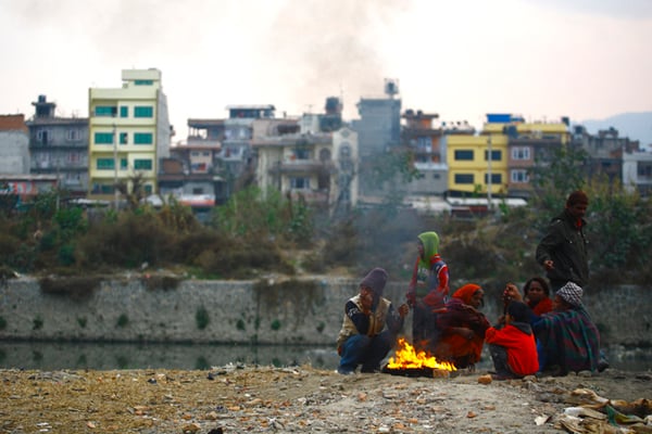 A family of squatters burn tyres to keep themselves warm on the banks of Bagmati River at Teku on Wednesday. Cloudy weather in the valley has resulted in a sharp decrease in temperature over the week.