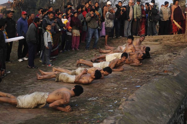 ROLLING IN THE DEEP : Hindu devotees perform a ritual on the last day of the month long Madhav Narayan festival in Bhaktapur on Monday.