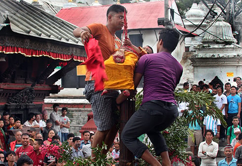 A child is kept at sword point on top of a chariot to mark the Trishul Jatra at Pashupati, Kathmandu on Friday.