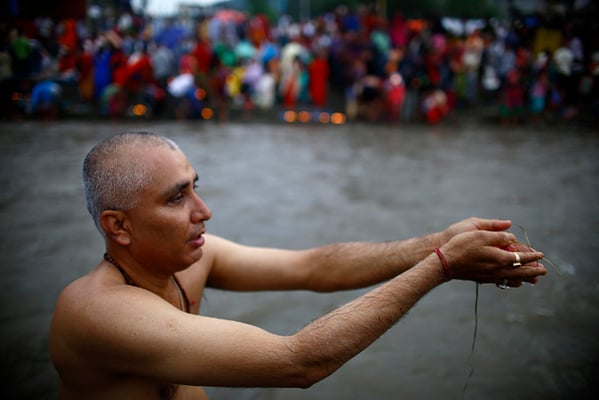 A devotee takes a holy bath before performing religious rituals to mark Kuse Aunsi, or Father's Day, on the bank of Bagmati River at Gokarna Temple in Kathmandu on Monday. For those who have lost their fathers, visiting Gokarneshwor temple on this day gives them an opportunity to remember them.