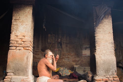 A sadhu gets ready for the Maha Shivaratri festival by smearing himself with white ash at Pashupatinath Temple on Tuesday.