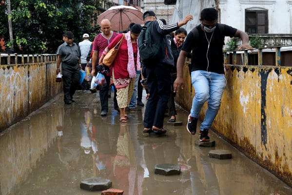 Pedestrians negotiate a flooded overhead footbridge in Kathmandu after heavy monsoon downpour on Tuesday.
