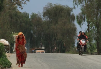WAYS OF TRANSPORTATION: A woman carries fodder while bike riders head towards their destination in Dhulikhel on Monday.