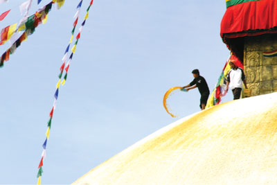 TIME FOR A MAKEOVER: A worker sprinkles water on the freshly painted white dome at Boudhanath stupa.