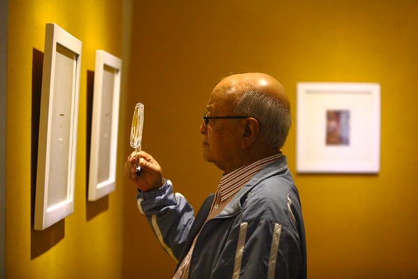 Himalaya Shumsher Rana, former Governor of Central Bank of Nepal, looking at miniature paintings during the exhibition, titled Embodied Enlightenment, of Samundra Man Singh Shrestha's artworks at Nepal Art Council, Kathmandu on Monday.
