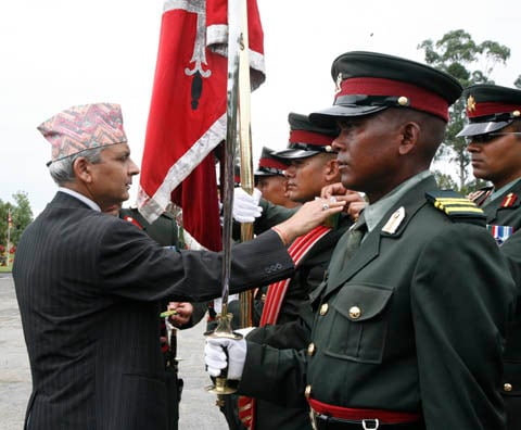 SECOND INNINGS: Chairman of interim council of ministers Khil Raj Regmi present insignia of lieutenant rank to former Maoist combatant at Nepal Army Academy, Bhaktapur on Monday.