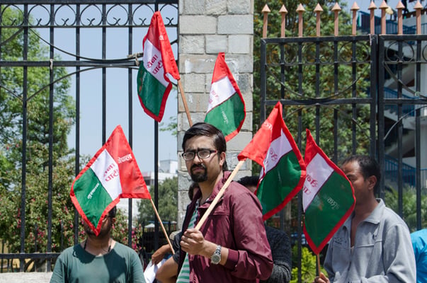 A man holding banners of his party participates in a rally to demand party election symbols in Kantipath on Saturday.