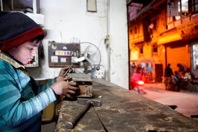 REALITY BITES: A 11 year-old boy repairs a piece of a water pump at a workshop in Bangemuda on Tuesday evening.