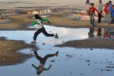 CATCH THIS IF YOU CAN: Children stone skipping on a puddle formed at Siphal Chaur by the weekend's rain on Tuesday.