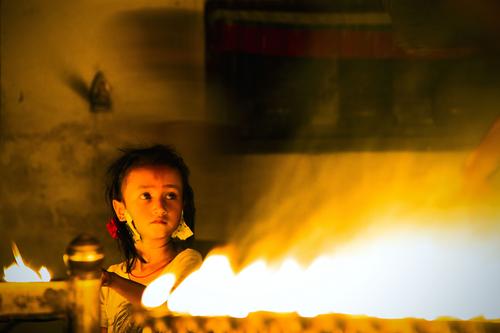 A child lighting candle at the premise of Boudhanath Stupa in Kathmandu on Saturday.