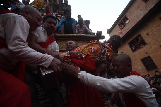 Devotees carry the idol of Rato Machendranath into the chariot at Bungamati on Sunday.