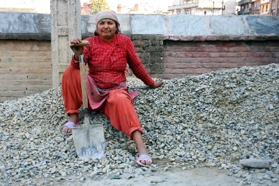 HARD LIFE: A woman takes a rest from her work of shovelling stones in Patan on Friday.