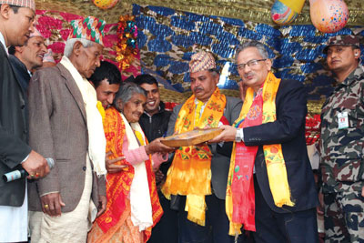 SENIOR CLASS: PM Bhattarai honours Okhaldhunga resident Narmada Bhattarai on Monday during the anniversary of Gramodaya Yugakavi School as Bal Krishna Dhungel looks on (centre).