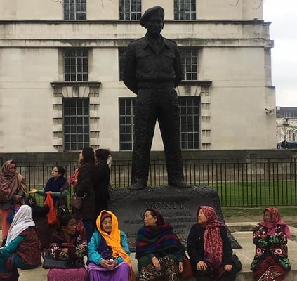 Wives of retired British Gurkha soldiers rest below statue of Field Marshal Montgomery in London on Wednesday during protests over veterans' pensions.