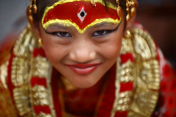A young girl dressed as a Kumari (living goddess) looks on during a mass worship at Hanuman Dhoka Darbar Square in Kathmandu on Saturday