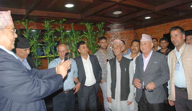 UML Chairman KP OIi has a photograph taken by Home Minister Bam Dev Gautam at Tribhuvan International Airport on Tuesday on return from Singapore after medical treatment.