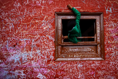 A boy writes on the wall of the Saraswati temple at Swayambhu on the occasion of Shree Panchami on Sunday.