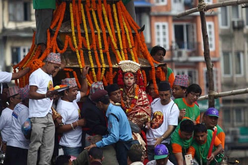 A devotee carries the living goddess locally known as Kumari to a chariot during the week-long Indra Jatra festival in Kathmandu on Monday.