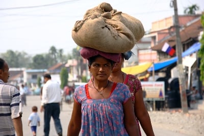 HEAVY HEAD: Women carry sacks on their head as they walk down the main road in Letang on Friday morning.
