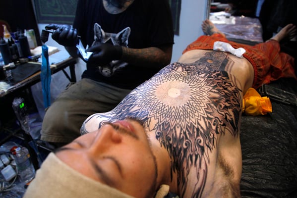 A man gets a tattoo on his torso on the last day of the sixth International Tattoo Convention in Kathmandu on Sunday. Over 150 tattoo artists from around the world participated in the three-day event.