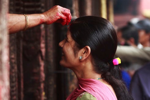 STRINGS ATTACHED: A woman celebrating Janai Purnima at Baglmukhi temple in Patan on Wednesday.