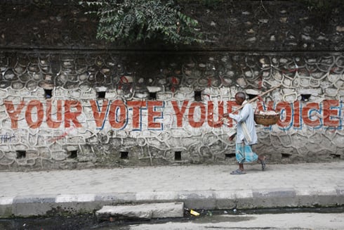 WRITING ON THE WALL: A man walks past a wall with election grafitti at Kupandol on Monday.