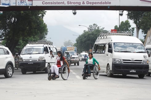 WHEEL POWER : Girls navigate traffic at the busy Bhadrakali intersection in their wheelchairs on Tuesday.