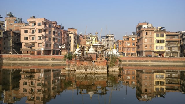 The earthquake-damaged resting place in the middle of the Pim Bahal pond against the backdrop of the changing cityscape of Patan on Monday.