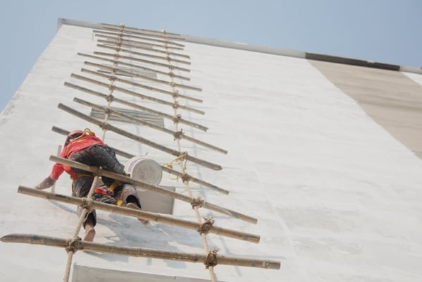 RISKY BUSINESS: Workers paint a high-rise commercial building at Pulchok on Sunday afternoon.
