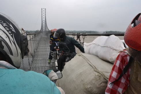 INCH BY INCH: Men use their motorcycles to carry goods and passengers across the Mahakali River to Chandni, Kanchanpur, on Friday.