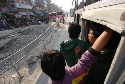 HOLD ON: A bus conductor and passengers cling onto an overcrowded bus as it travels from Kabhre towards Kathmandu on Sunday.