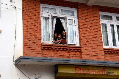 LITTLE MISCHIEF: Children wait by a window with a bucket of water to splash on passers-by days before Holi celebrations at Khokana on Saturday.